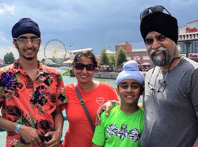 Dr. Singh and his family smiling outdoors