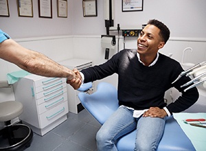 Man smiling and shaking hands with his Cary dentist 