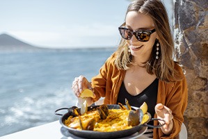 Smiling woman enjoying meal at restaurant on the water