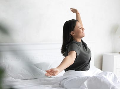 Woman waking up refreshed thanks to sleep apnea treatment