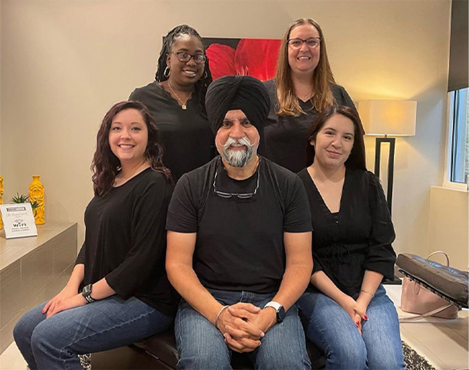 Cary dentist Doctor Bikram Singh smiling with the team at Cary Dental Rejuvenation