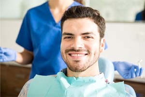 Bearded man smiling in dental chair after cosmetic dentistry in Cary, NC