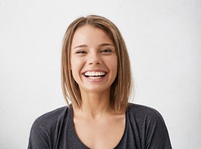 young woman smiling after seeing her cosmetic dentist in Cary 