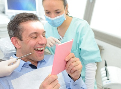 Patient with dental bridge in Cary looking in mirror