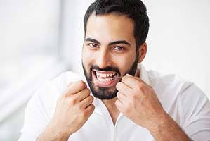 Man flossing teeth in Cary