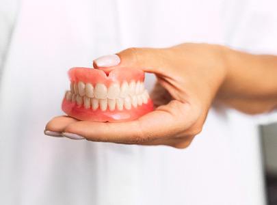 dentist holding dentures