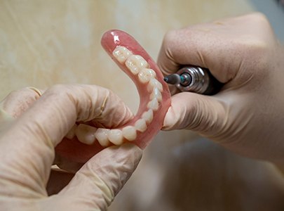 Dental technician polishing a denture