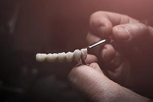 Dental technician painting artificial teeth