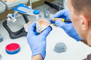 Dental technician carving denture mold