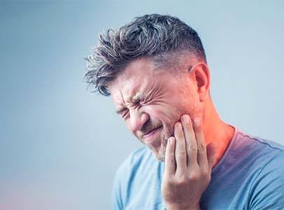 man in dental pain who needs a tooth extraction in Cary, NC