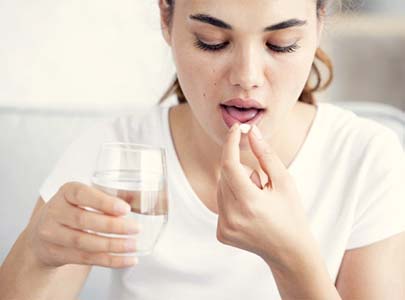 woman taking pain medication after a tooth extraction
