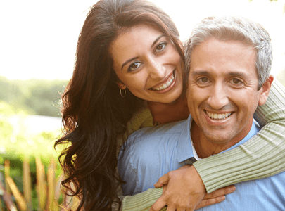 Man and woman outside smiling with dental implants in Cary, NC