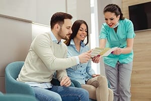 Young couple learning about in-house dental discount program