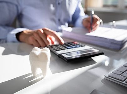 Dentist calculating dental insurance coverage