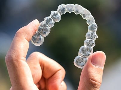 person holding Invisalign aligners in Cary