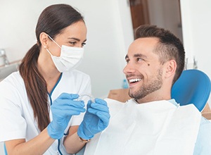 Smiling patient and dentist discuss the price of Invisalign in Cary