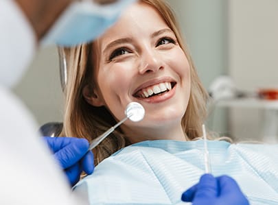 Woman in dental chair smiling at Cary dentist