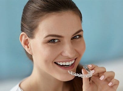 Woman placing an Invisalign tray