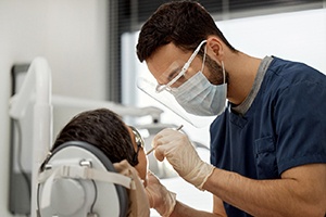 A male dentist screening his patient for oral cancer