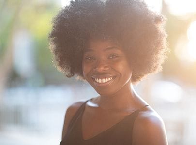 person standing in a park and smiling