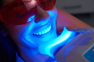woman getting her teeth whitened in dental office