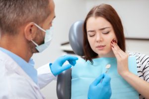 young woman with toothache talking to emergency dentist in Cary 