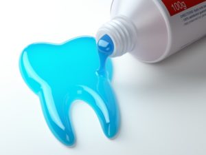 blue toothpaste coming out of the tube in the shape of a tooth 