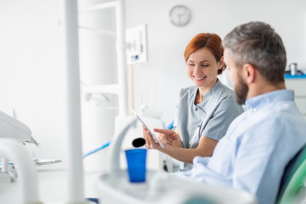 Dentist explaining Invisalign treatment to patient