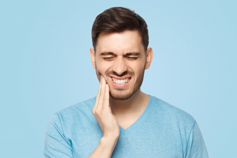 a man hurting from an object stuck between his teeth