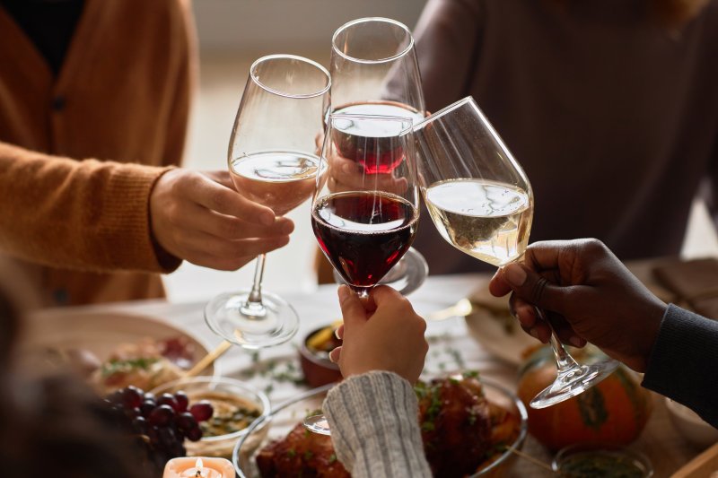 Friends with good oral health enjoying wine for the holidays