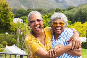 Two women hugging and smiling while outdoors